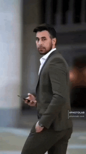 a man in a suit holding a cell phone in his hand