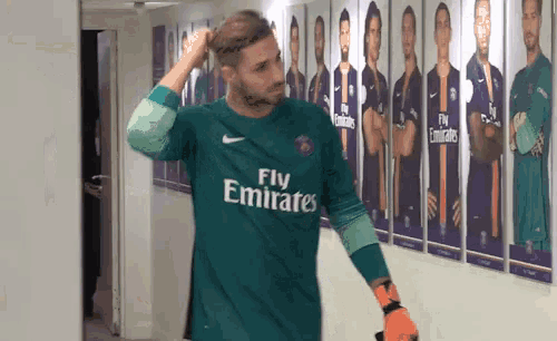 a man wearing a green fly emirates jersey