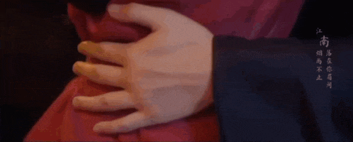 a man and a woman are kissing in front of a dark background .