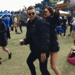 a man and a woman are dancing in a field