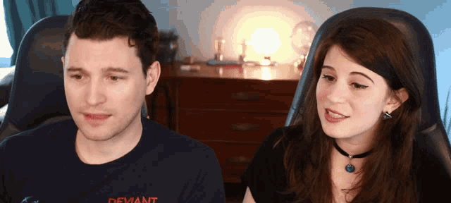 a man and a woman are sitting next to each other with the man wearing a shirt that says deviant