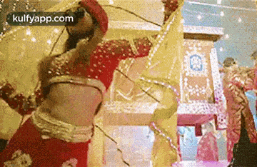 a woman in a red dress is dancing in a room with a yellow cloth .