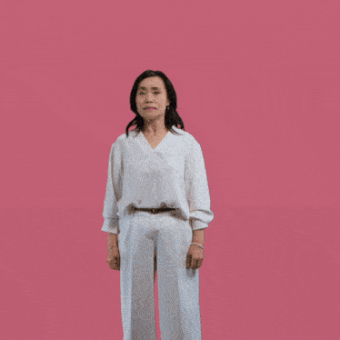 a woman in a white shirt and white pants is dancing