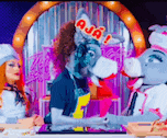 a man with a donkey 's head and a chef 's hat is cooking with two women .