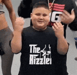 a young boy wearing a t-shirt that says `` the rizzle '' is making a funny face .