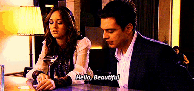 a man and a woman are sitting at a bar talking to each other and the man is saying hello beautiful .