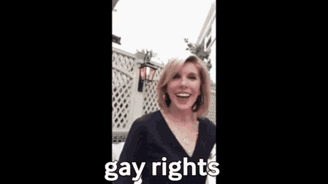 a woman is holding her fist up in the air and saying gay rights .
