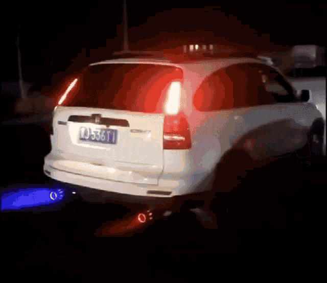 a car is driving down a dark street at night with the lights on .