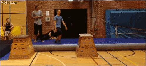a man jumps over a wooden box in a gym with a 4gifs.com watermark