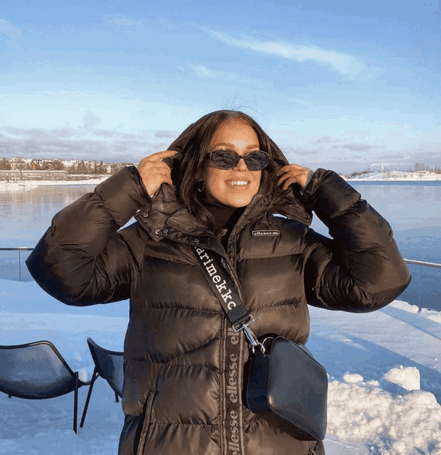 a woman wearing a black jacket with a strap that says marimekko on it