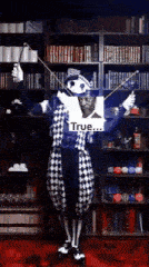 a man in a clown costume is holding a wand and a sign that says true