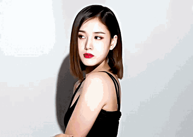 a woman in a black tank top with red lipstick