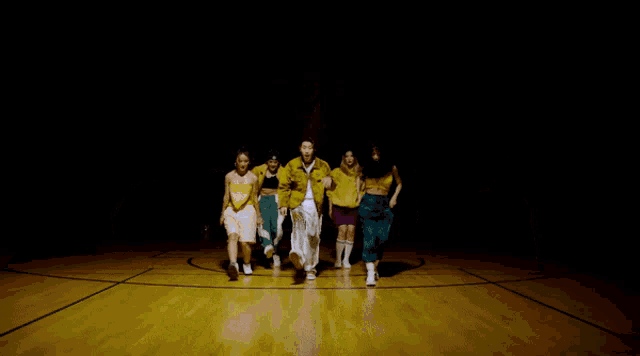 a woman in a yellow jacket is dancing with two other people