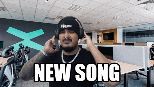 a man wearing headphones says " new song " on the screen