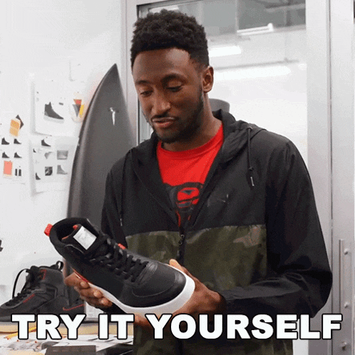 a man holding a pair of shoes with the words try it yourself written below him