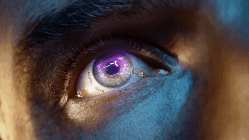 a close up of a person 's eye with a purple pupil that says the