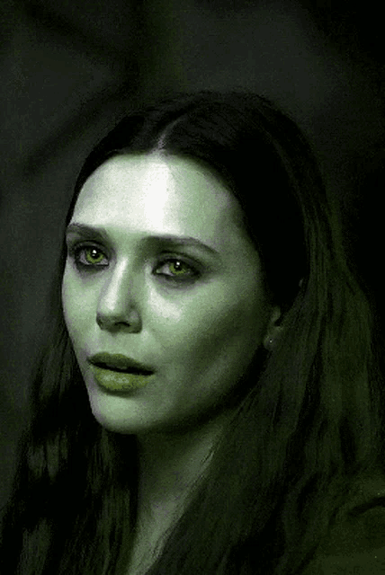 a close up of a woman 's face with green eyes