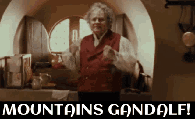 a man in a red vest is standing in front of a window with the words mountains gandalf on the bottom