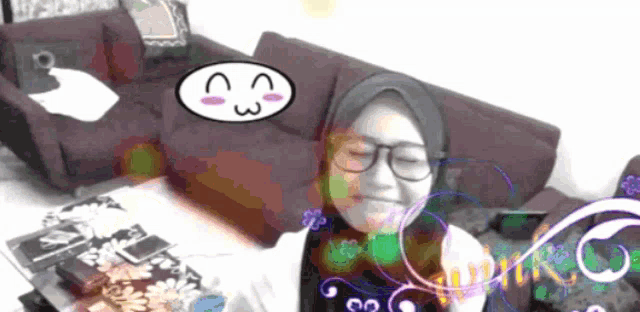 a girl with glasses and a hijab is sitting in front of a purple couch