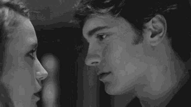 a man and woman are kissing in a black and white photo .