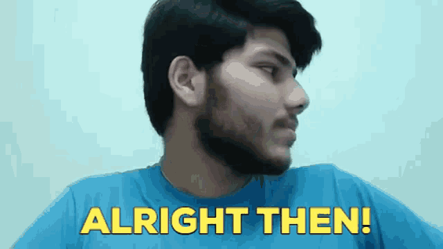 a man with a beard is wearing a blue shirt and says alright then .