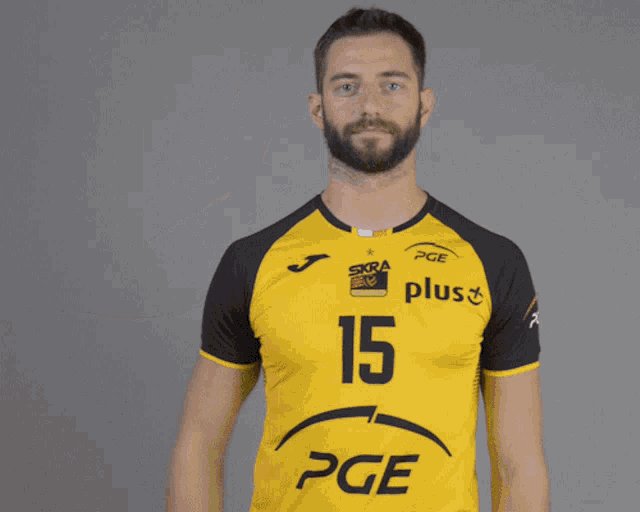 a man wearing a yellow and black shirt with the number 15