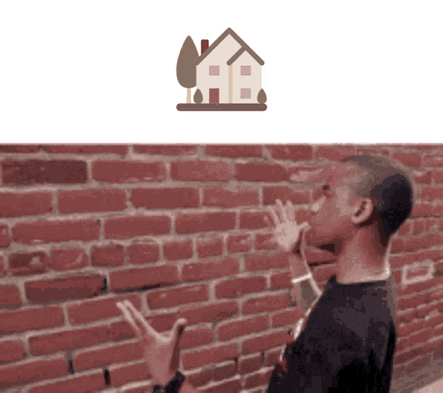 a man is standing in front of a brick wall with a house icon above him