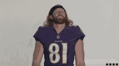a man with a beard wearing a purple jersey with the number 81 on it is dancing .