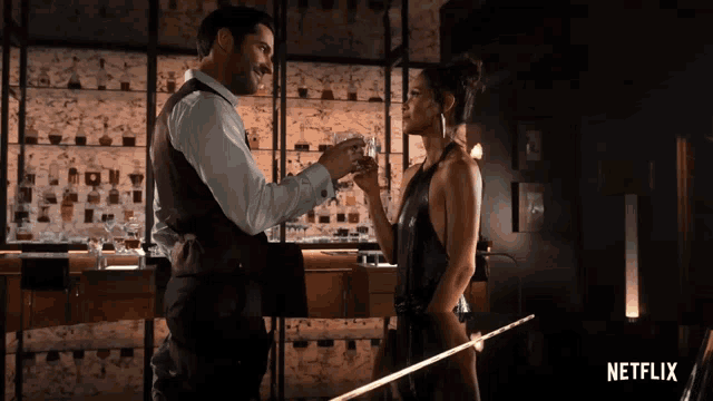 a man and a woman are standing next to each other with a netflix logo in the background