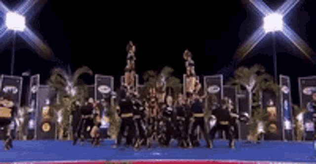a group of cheerleaders are performing a routine on a stage .