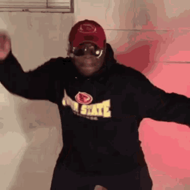 a man wearing a hat and sunglasses is dancing