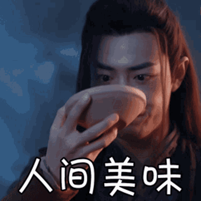 a man with long hair is drinking from a bowl with chinese characters on it
