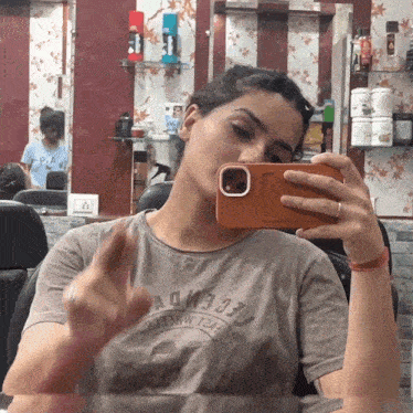 a woman taking a picture of herself in a mirror while wearing a t-shirt that says " admire "