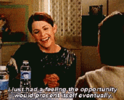 a woman is laughing while sitting at a table with water bottles and a man