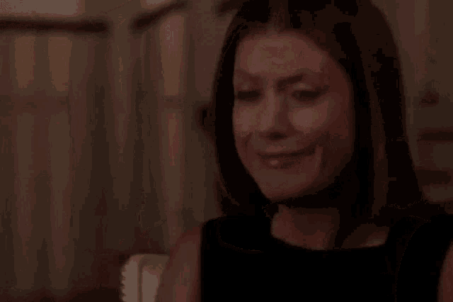 a woman is crying with a tear running down her face while sitting at a table .
