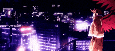 a person with wings is standing on a balcony overlooking a city at night .