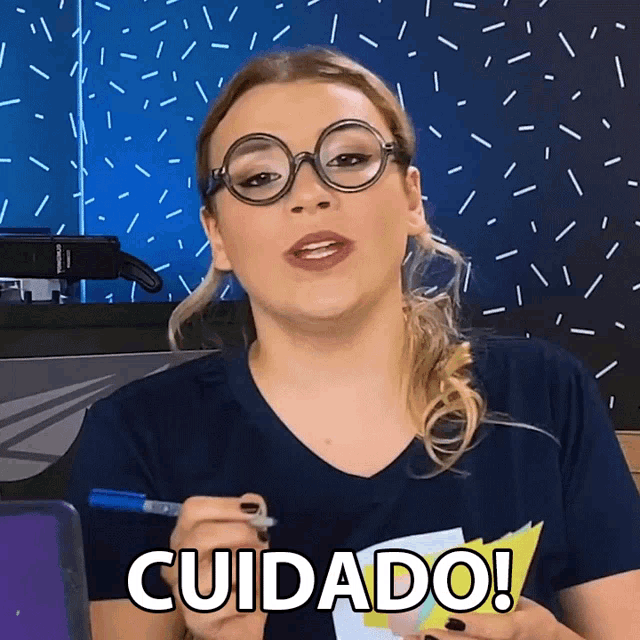 a woman wearing glasses and holding a marker says cuidado