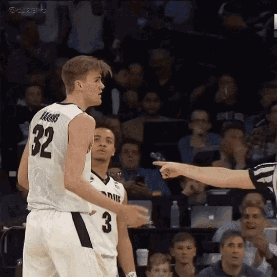 a basketball player with the number 32 on his jersey is pointing at another player