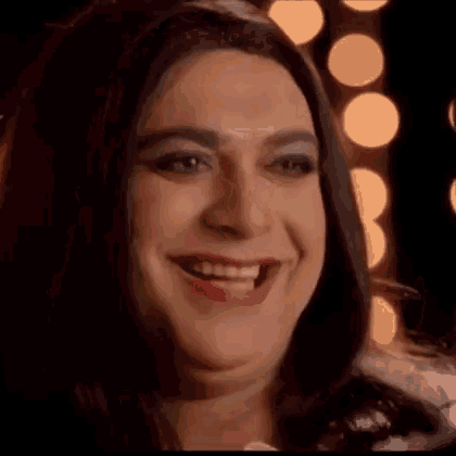 a close up of a person wearing a wig and makeup smiling .