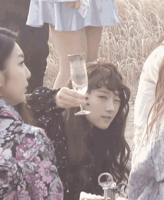 a woman holds up a glass of water in front of her face