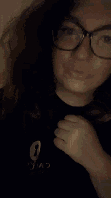a woman wearing glasses and a black shirt that says ninja