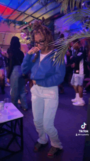 a woman in a blue jacket is singing into a microphone .
