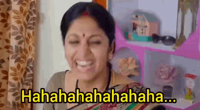 a woman is smiling and laughing in front of a pink shelf with the words ' hahahaha ' on it .