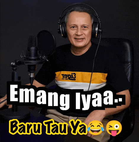 a man wearing headphones sits in front of a microphone with the words emang lyaa baru tau ya written below him