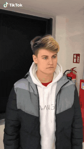 a young man wearing a jacket and a hoodie with the word wang on the front
