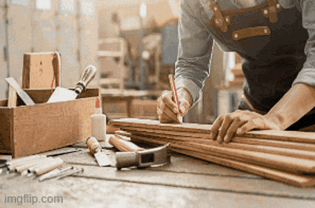 a man is measuring a piece of wood with a red pen