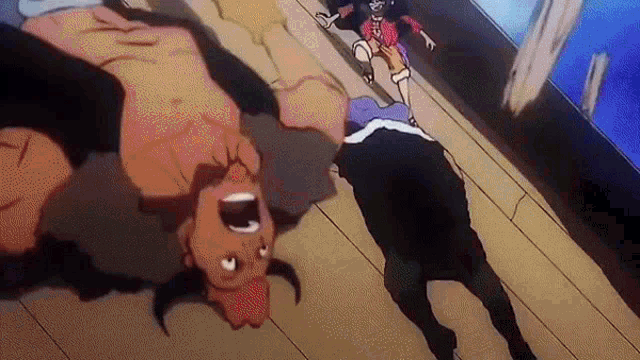 a man is laying on his back on a wooden floor while a woman stands next to him .