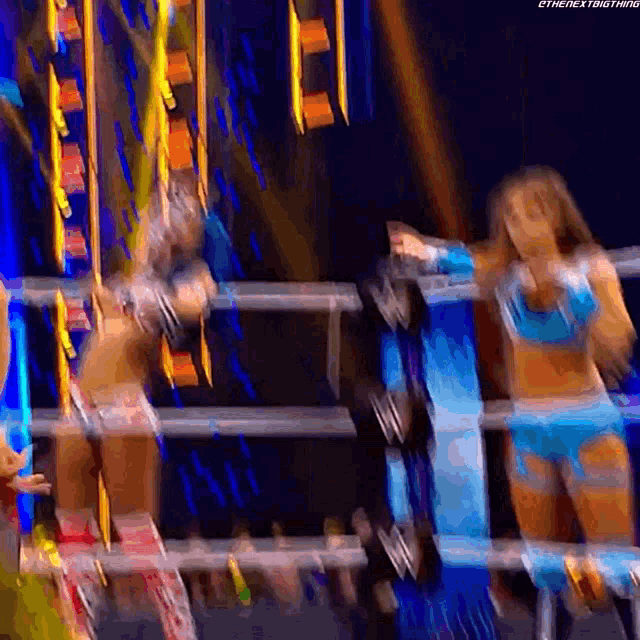 a blurry picture of two women wrestling in a wrestling ring .