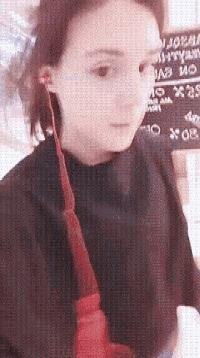 a girl wearing ear buds is standing in front of a sign that says ' no smoking ' on it