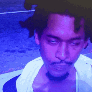 a man with dreadlocks and a beard is looking at the camera